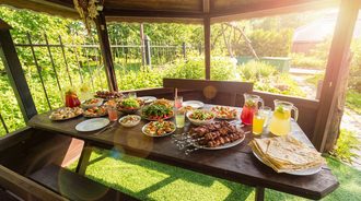 Стол в беседке с шашлыком, лавашом и лимонадом