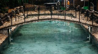 Бассейн с речной водой у кованого мостика